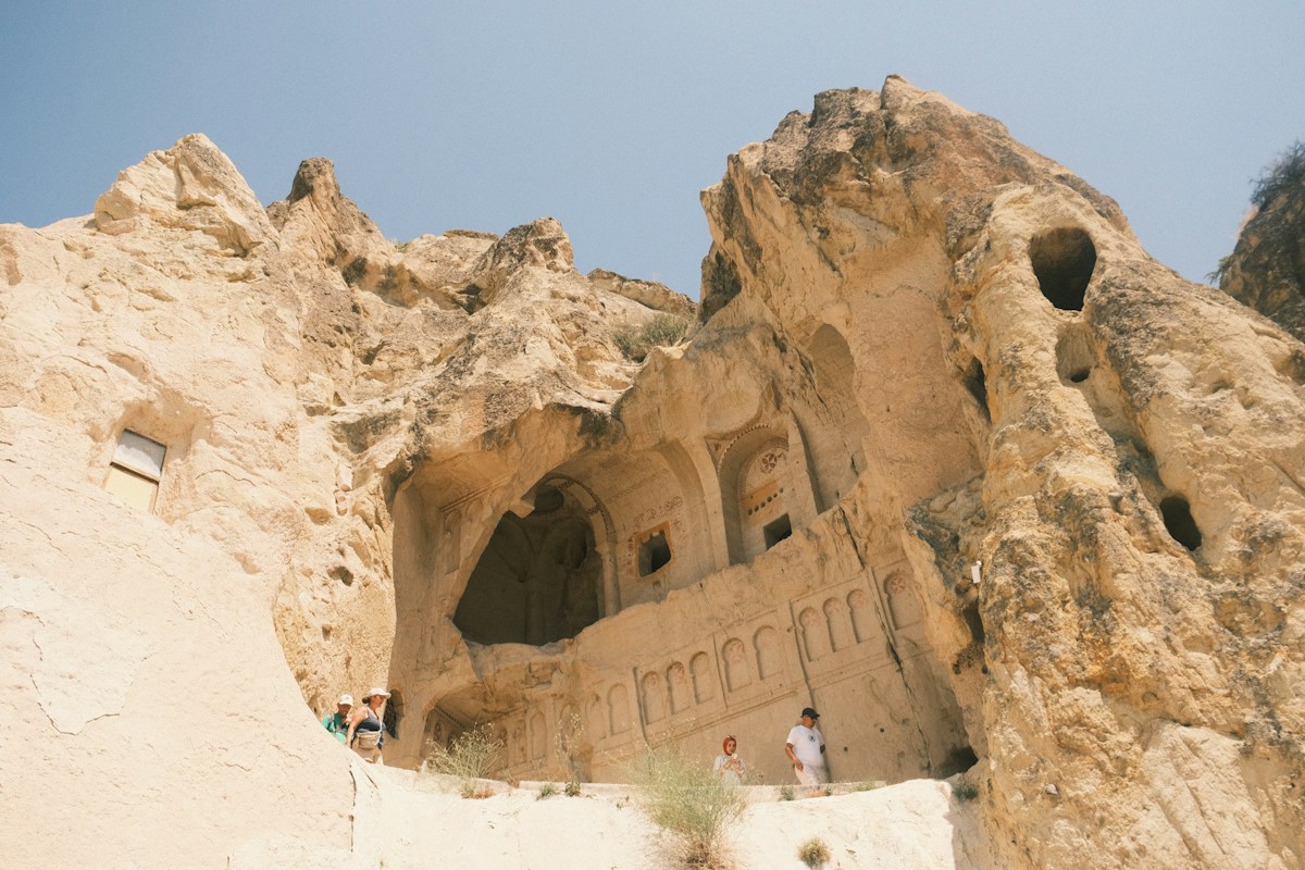 Ancient cave dwellings carved into a rocky hillside.